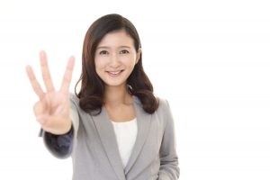 笑顔で3を示す女性